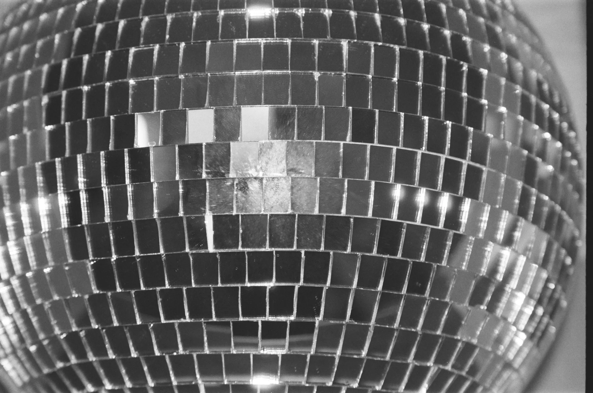 Black and white photo of a disco ball with square mirror tiles.